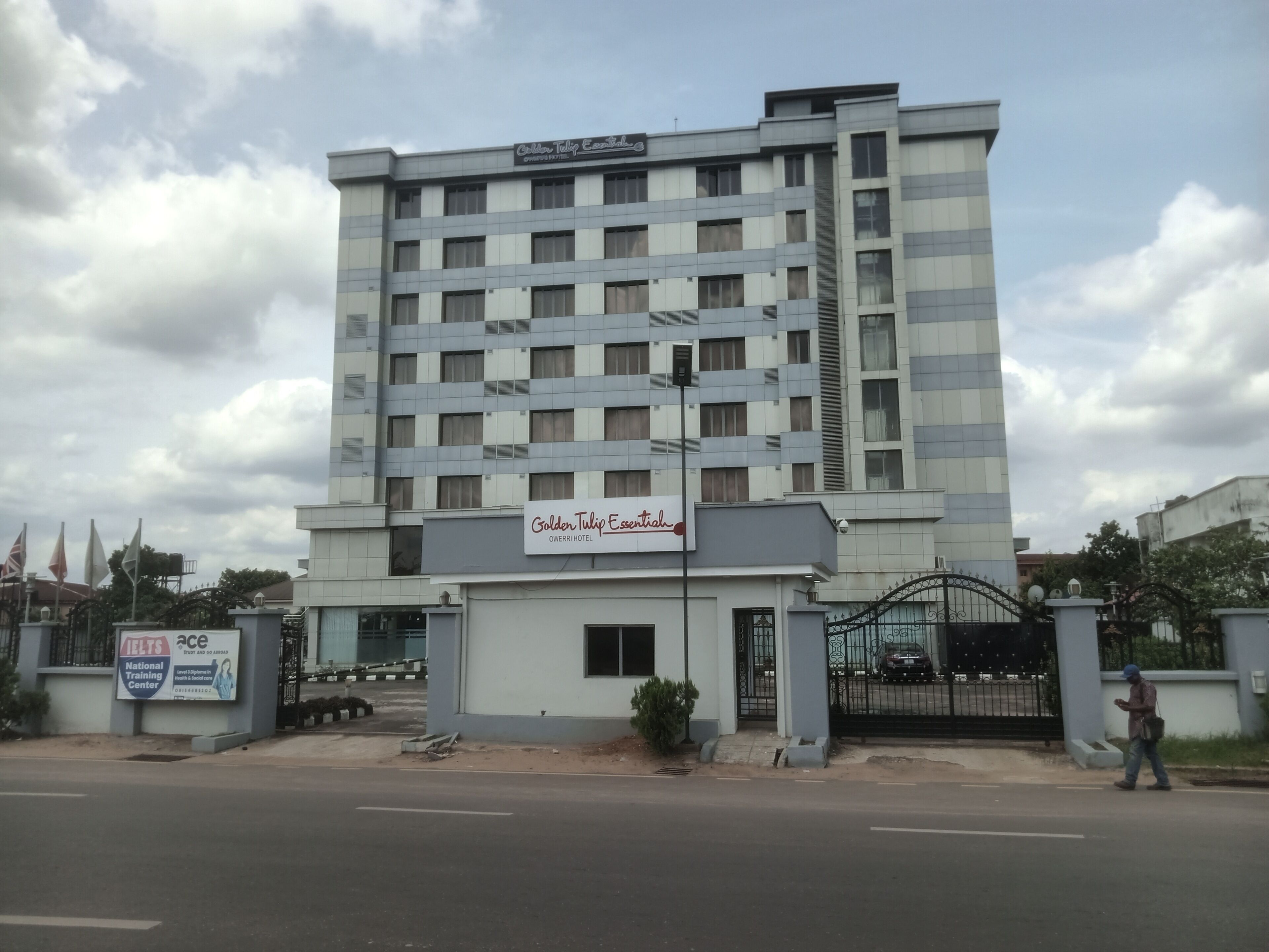 Un hôtel à plusieurs étages, avec une enseigne indiquant « Golden Tulip Essential » et « Owerri Hotel ».