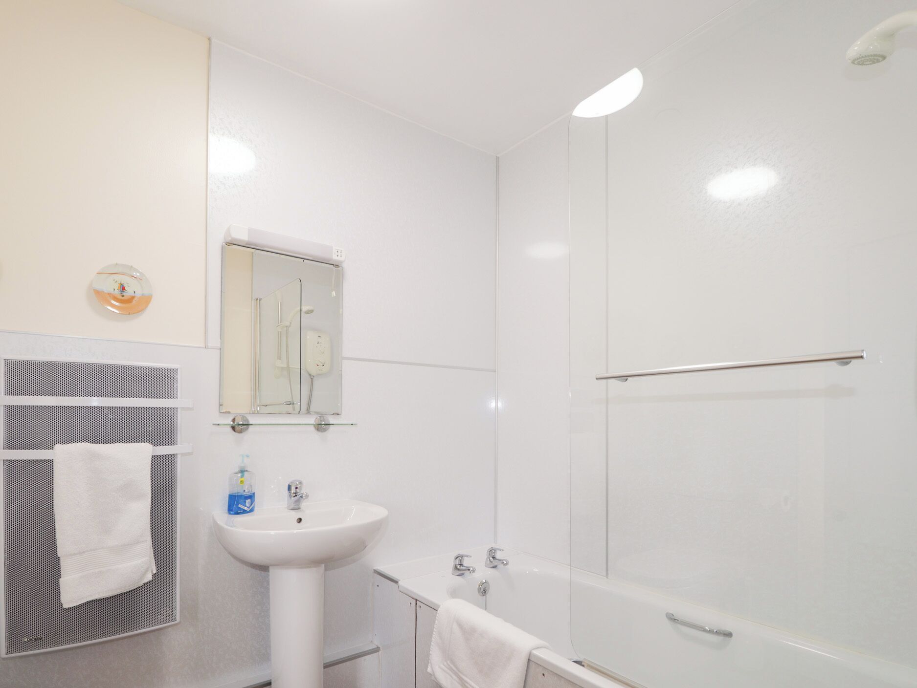 Ein modernes Badezimmer mit Waschbecken, Spiegel und Badewanne.