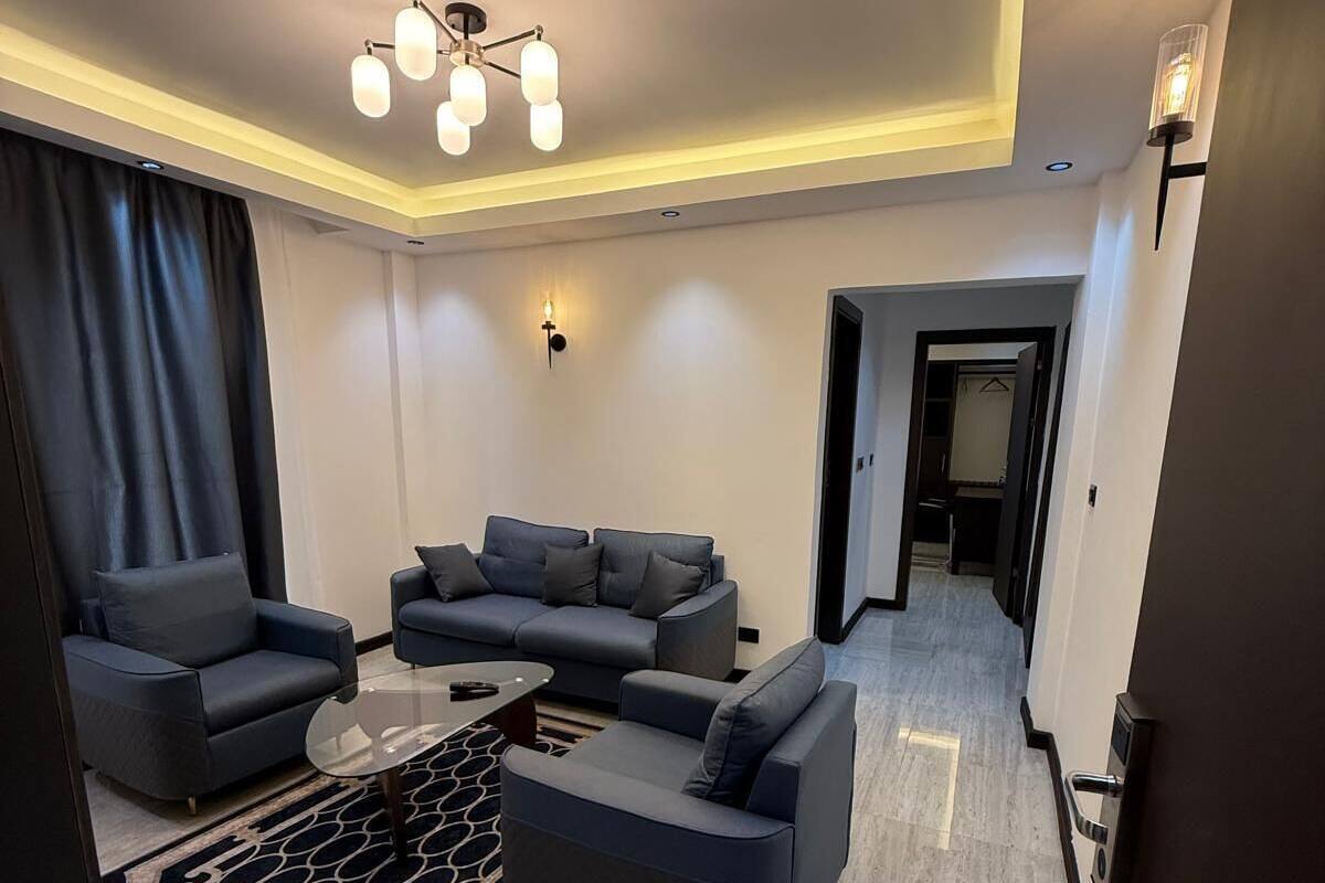 A modern living room with a sofa set, a coffee table, and a patterned rug.