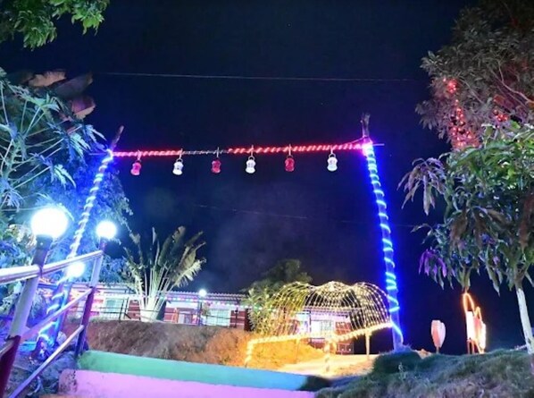A brightly lit archway with hanging lights and a structure beneath it.