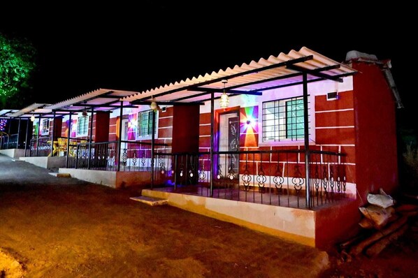 Un edificio de fachada roja, un porche cubierto y una entrada con portón.