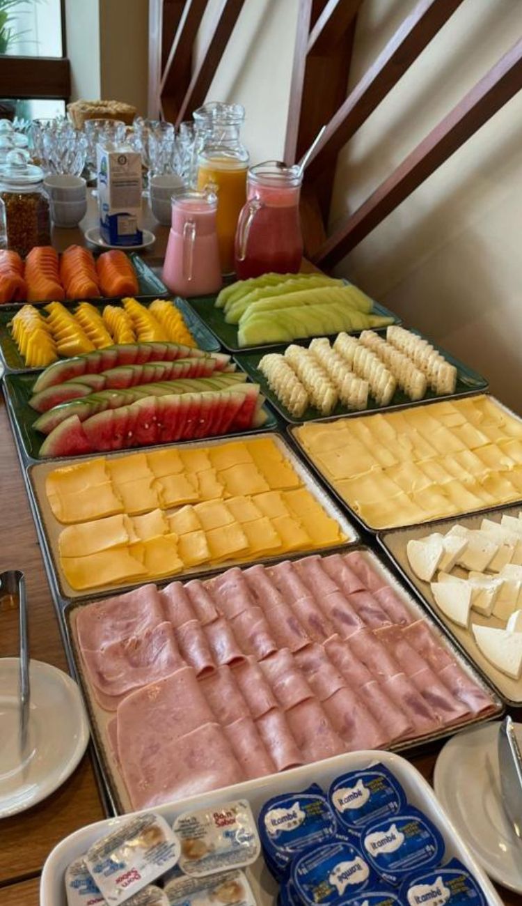 A buffet with various food items including fruits, cheeses, and meats.