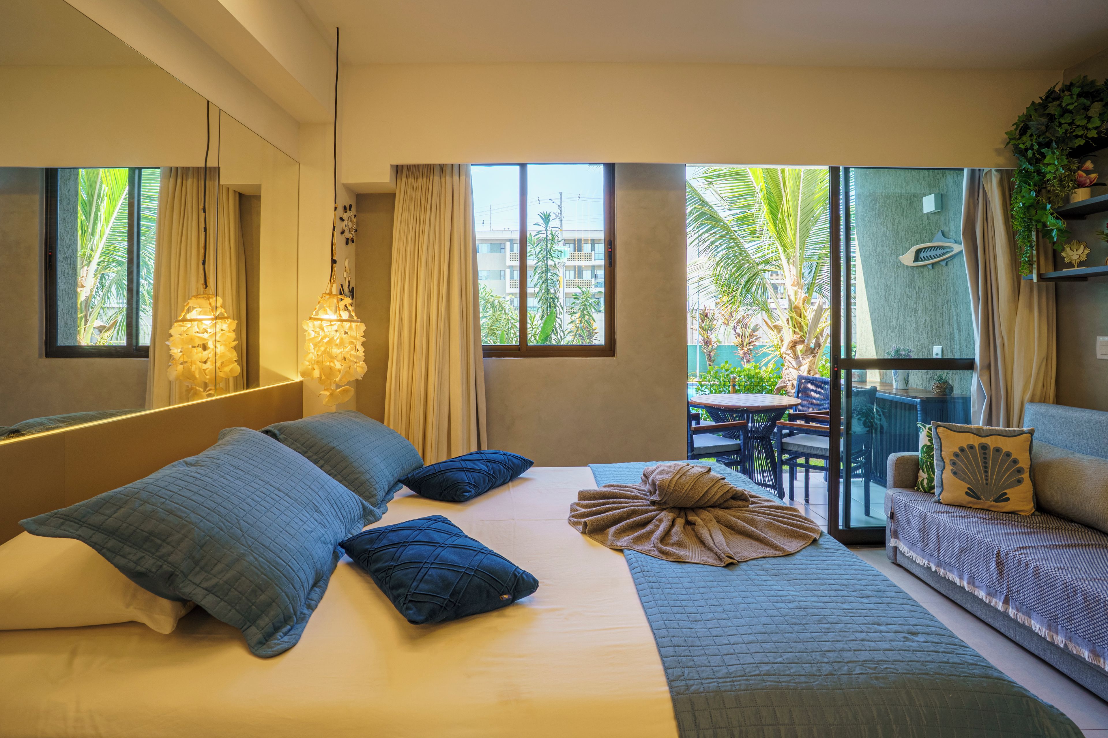 Quarto de hotel moderno com cama, varanda e vista para o exterior.