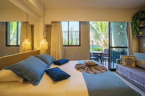 Habitación de hotel moderna con cama, balcón y vistas al exterior.
