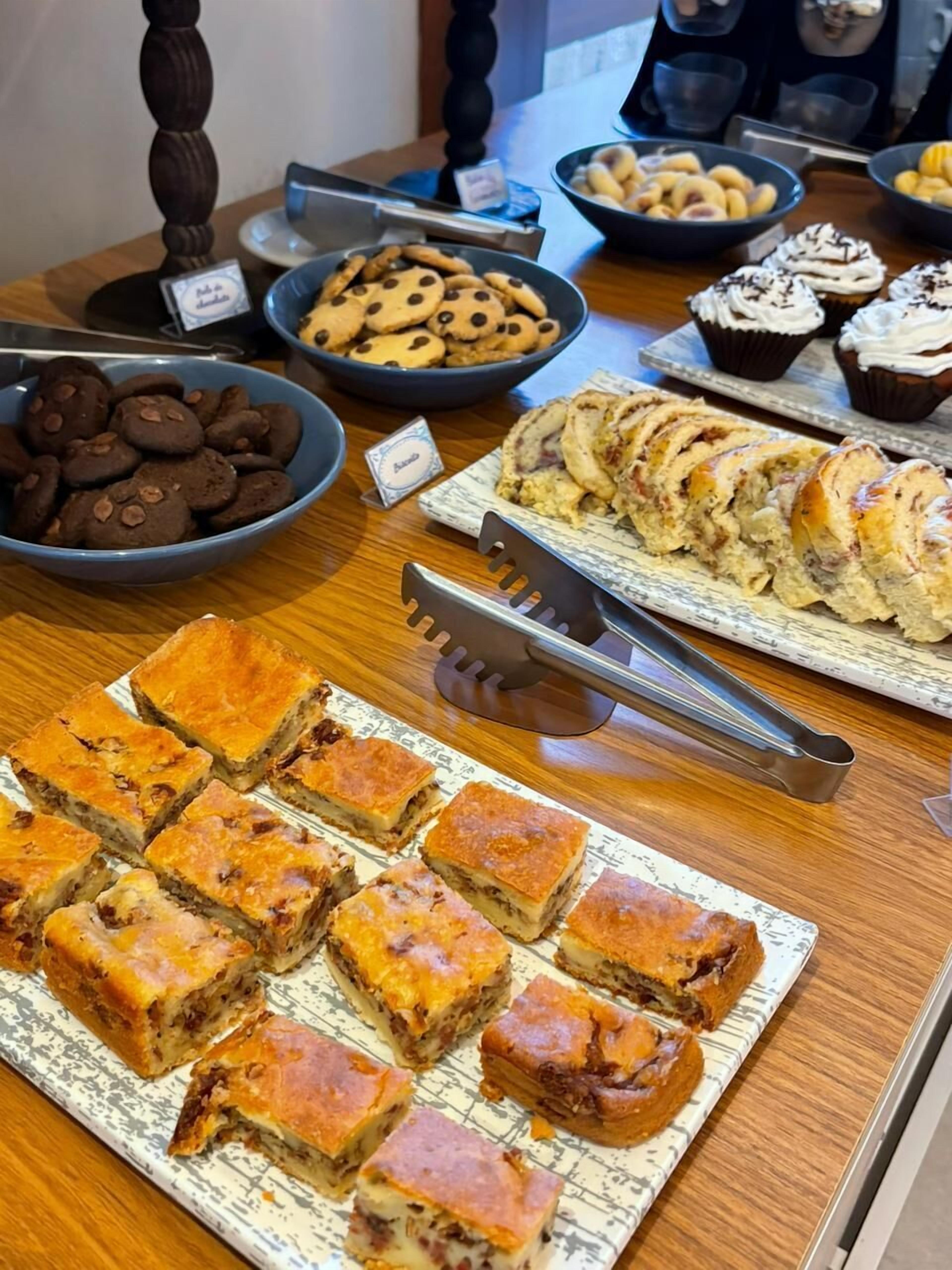 Ein Buffet mit verschiedenen Backwaren, darunter Kekse, Gebäck und eine Auswahl an Brot.