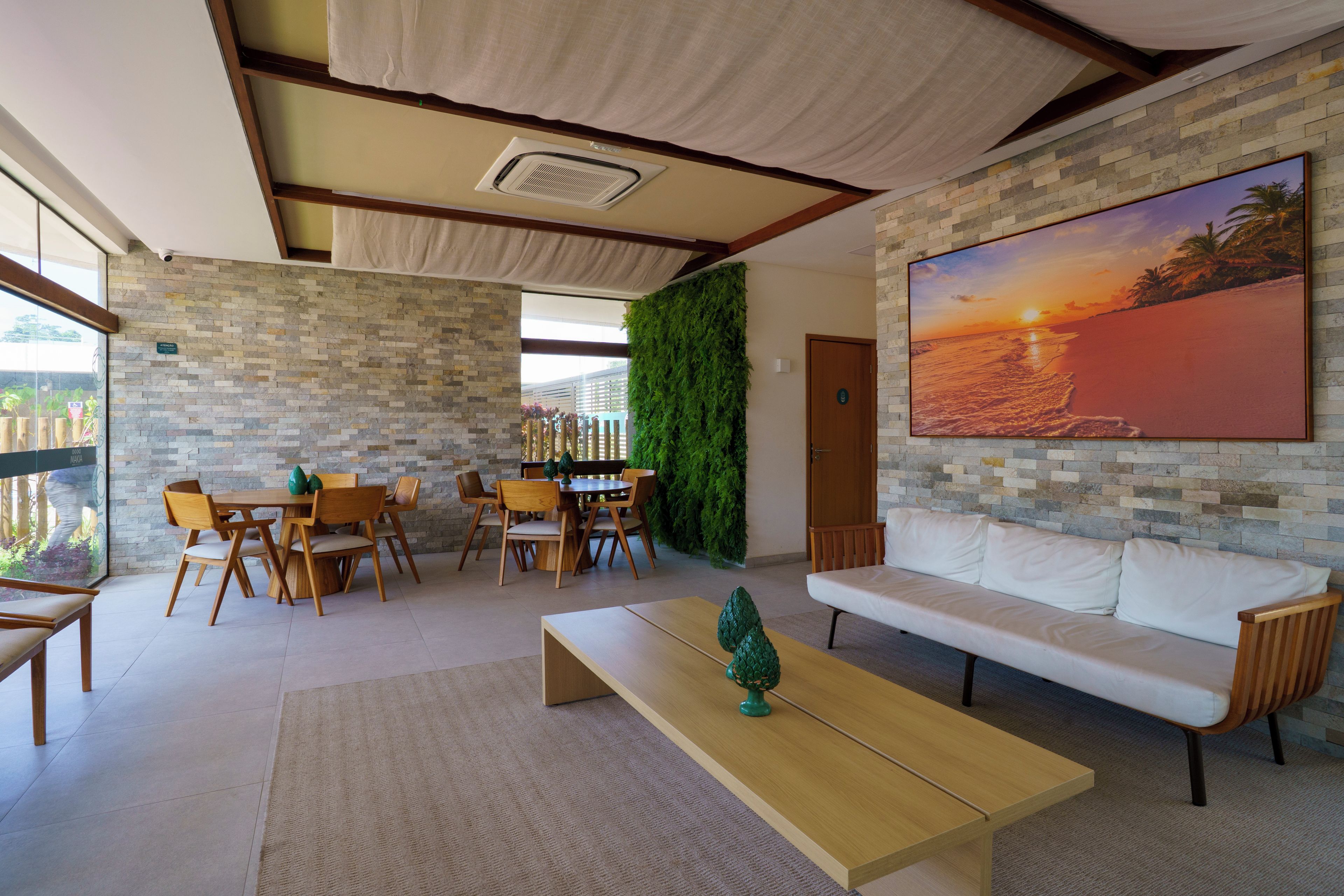 A modern interior with a dining area, a sofa, and a large painting of a sunset.