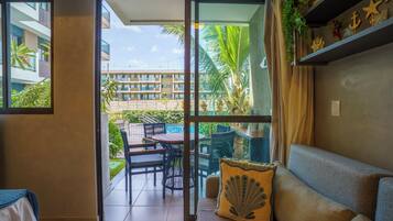 Una habitación con puerta de vidrio corrediza que da a un patio exterior con mesa y sillas.