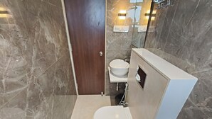 Une salle de bain moderne avec des toilettes, un lavabo et des murs en marbre.