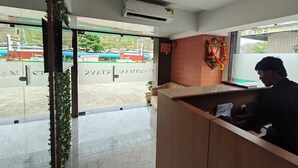 Une salle d’attente dotée d’un sol en marbre, d’un ventilateur de plafond et d’un appareil de climatisation.