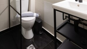 A modern bathroom with a toilet, sink, and mirror. - Astra Beach Studio 4 (Pylos-Nestoras)