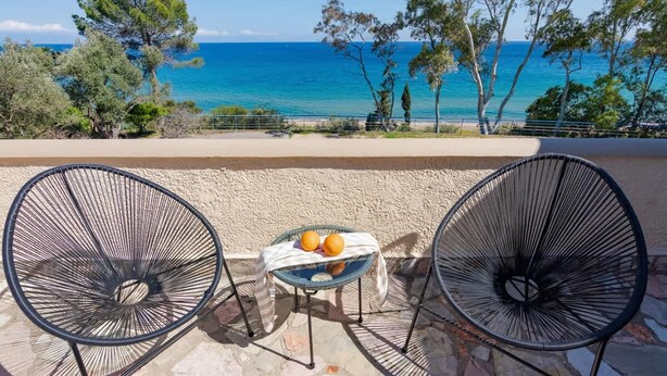 A terrace with two metal chairs and a small table with oranges, overlooking a beach and the sea. - Astra Beach Studio 4 (Pylos-Nestoras)