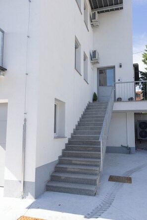 A multi-story building with a central staircase leading to a balcony. - Villa Andrea Apartments - Ljubljana (Ljubljana)