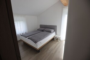 A modern bedroom with a bed, a nightstand, and a wooden ceiling. - Villa Andrea Apartments - Ljubljana (Ljubljana)