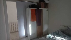 A bedroom with a bed, a wardrobe, and a radiator. - ST DE PARNAIBA APARTMENT (Chácara do Solar II Santana de Parnaíba)