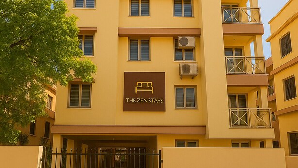 A multi-story hotel with a yellow facade, a sign reading "The Zen Stays," and a gated entrance. - The Zen Stays (Danapur)