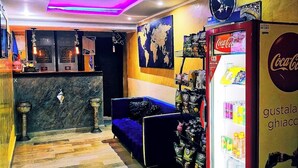A lobby with a blue sofa, a Coca-Cola refrigerator, and a world map on the wall. - Hotel Dar Ali  (Tunis)
