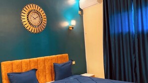 A bedroom with a large bed, a wall clock, and a ceiling light. - Hotel Dar Ali  (Tunis)