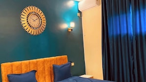 A bedroom with a large bed, a wall clock, and a window with curtains. - Hotel Dar Ali  (Tunis)