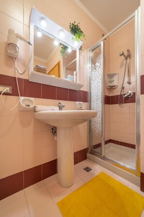Ein Badezimmer mit Waschbecken, Spiegel und Dusche.