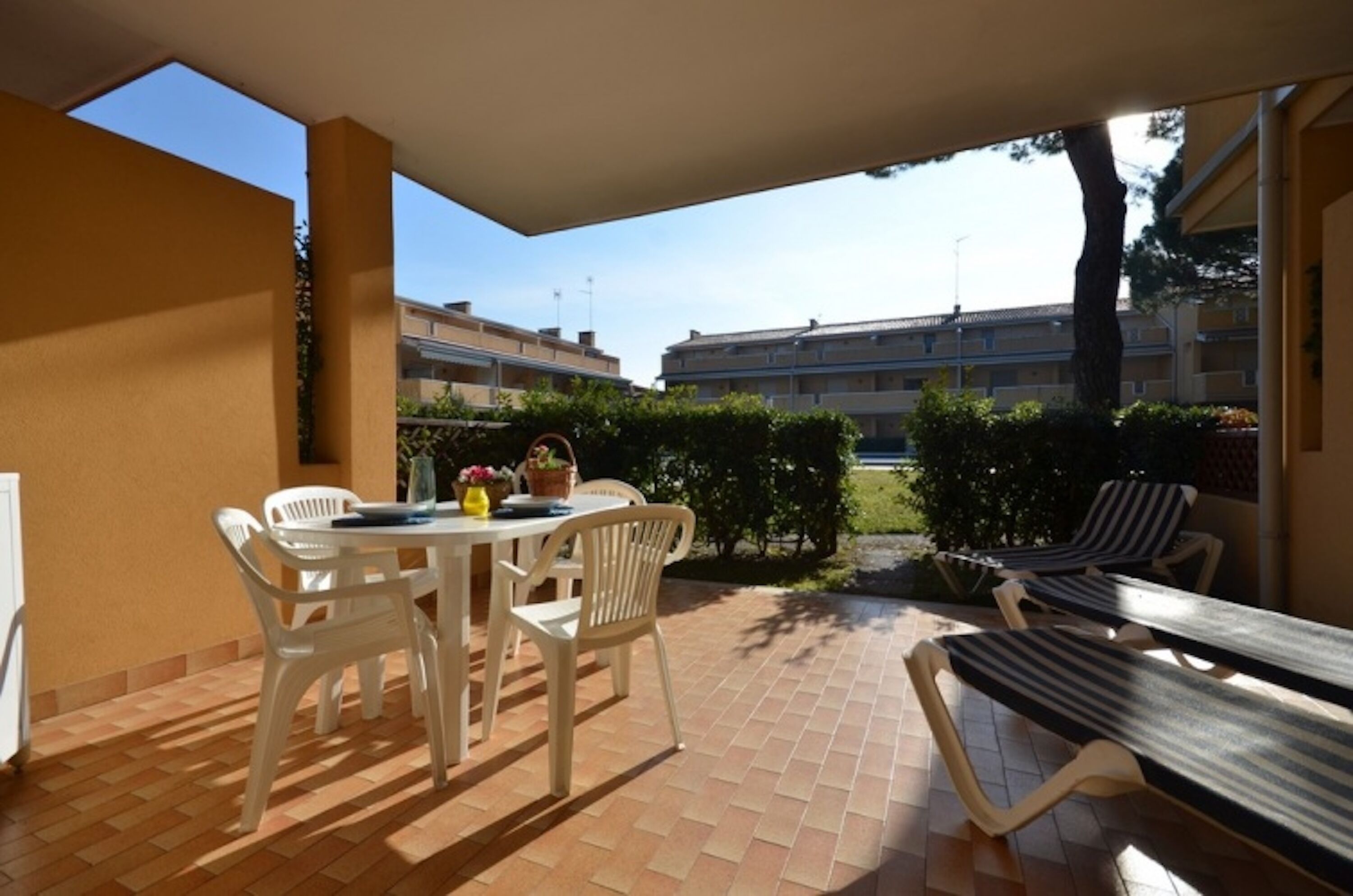 A patio with a table and chairs, a bench, and a view of buildings in the background.