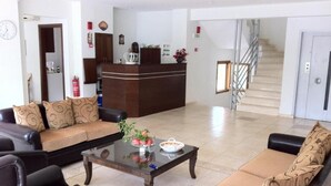 A hotel lobby with a reception desk, a staircase, and seating areas. - Hotel Magnolia (Istiaia-Aidipsos)