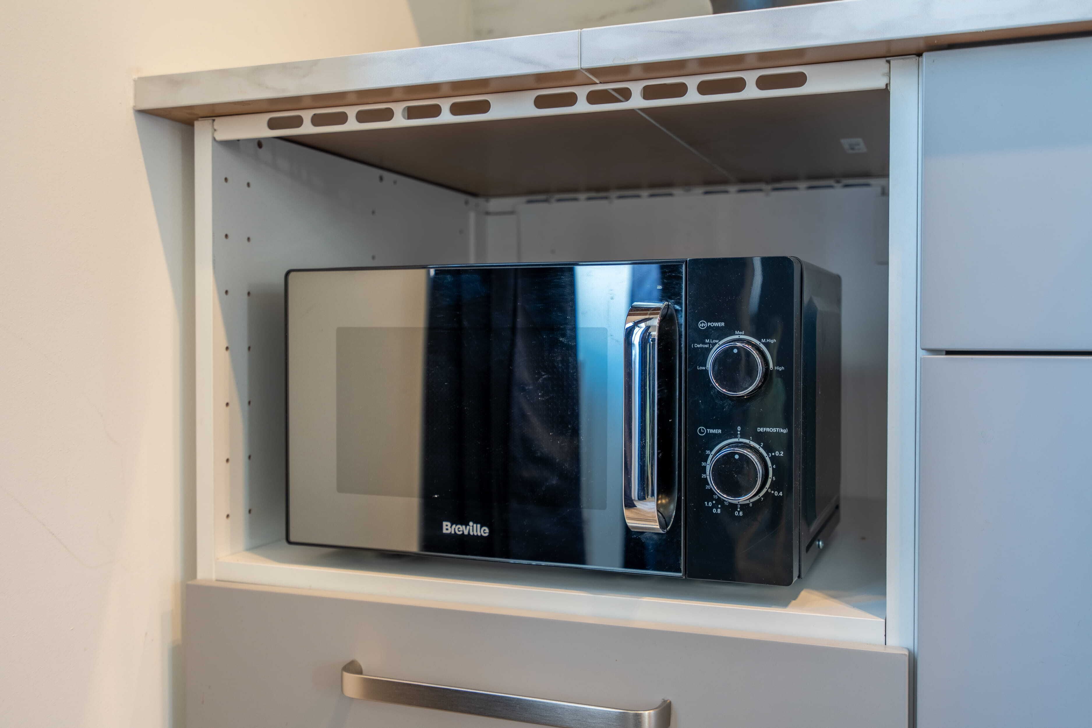 Un four à micro-ondes de la marque Breville, placé dans un meuble de cuisine.