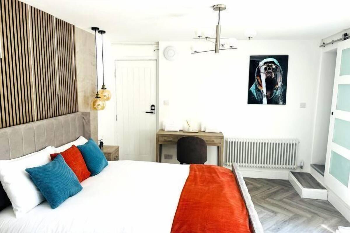 A modern bedroom with a bed, a desk, and a radiator.