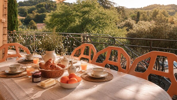 A table set for breakfast with croissants, oranges, and tea, overlooking a scenic landscape. - Beautiful home in Sablet (Sablet)
