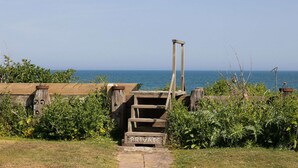 A wooden gate with a 'PRIVATE' sign, leading to a path by the sea. - Historic Railway Home - Selsey Seafront (Chichester)