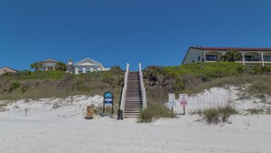 A beachside hotel with a staircase leading to a building with a red roof. - Seagrove Charm + Free Activity Tickets: Bikes, Dolphin Cruise & More! (Santa Rosa Beach)
