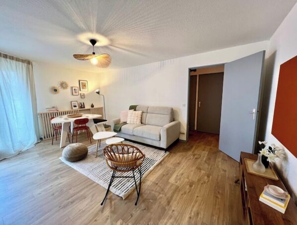 Un salon moderne comprenant un canapé, une table à manger, des chaises et un fauteuil décoratif.