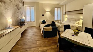 Una habitación de hotel pequeña con cama, mesitas de noche, escritorio y una silla.