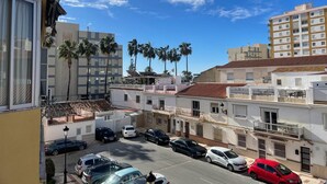 A residential street with parked cars, palm trees, and multi-story buildings. - TERRASOL PLAZAMAR 6-2 (Torre del Mar)