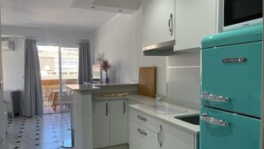 A compact kitchen with white cabinets, a turquoise refrigerator, and a tiled floor. - TERRASOL PLAZAMAR 6-2 (Torre del Mar)