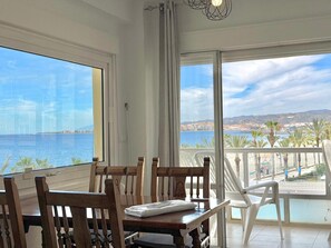 A balcony with a view of the sea and a cityscape.