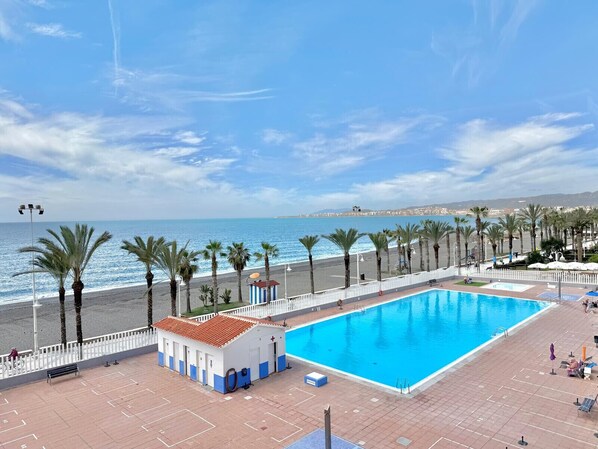 A swimming pool with a view of the beach and ocean.