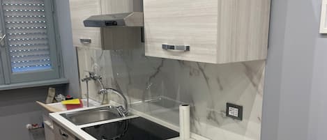 A modern kitchen with a built-in stove, sink, and cabinets.