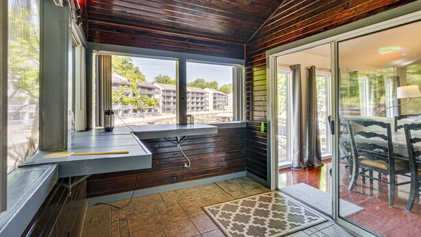 A room with wooden walls, a window, a door, and a table with chairs. - Private Dock + Lake View: Spacious Ozarks Retreat (Osage Beach)