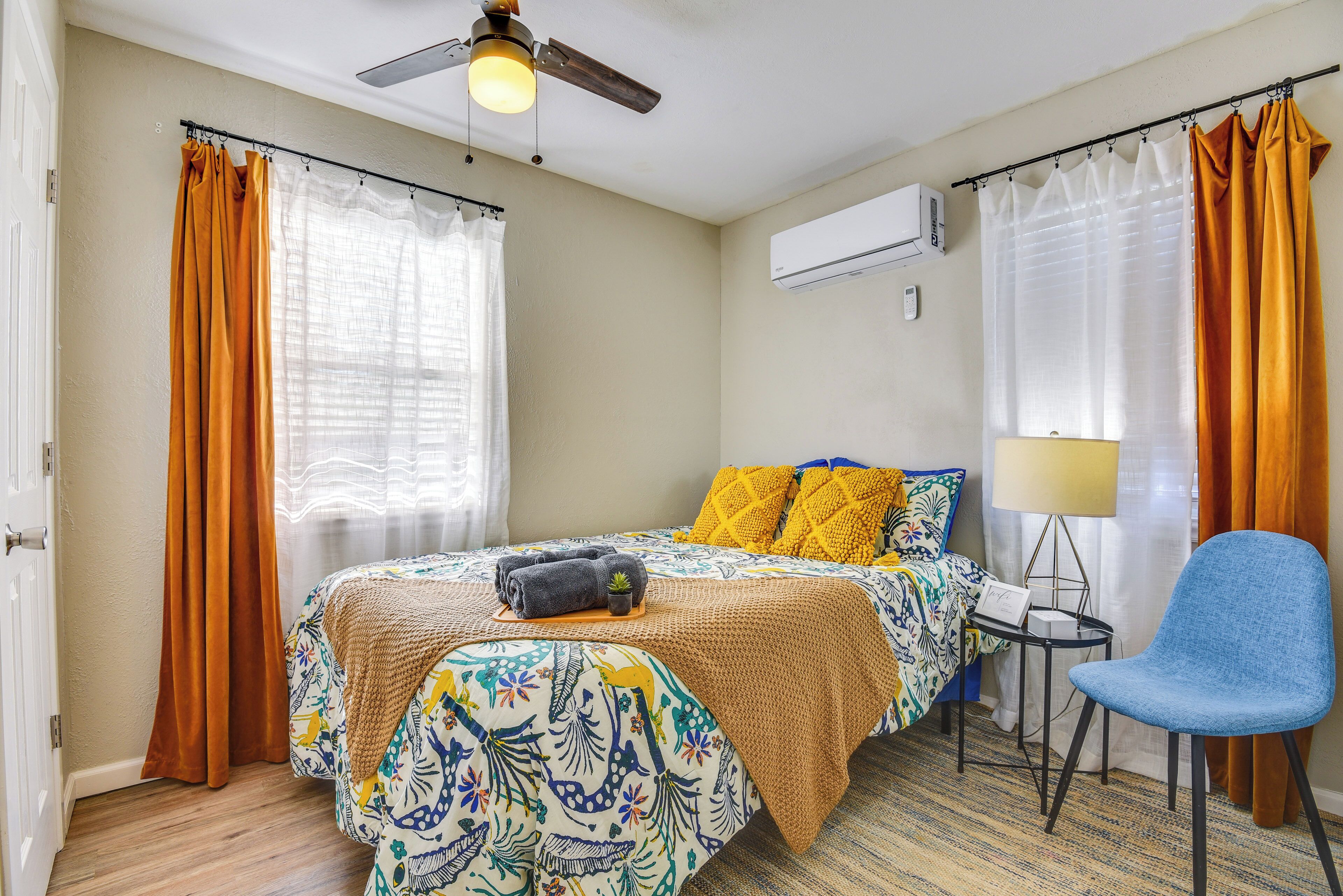 Una habitación de hotel con una cama, una silla, una lámpara y un equipo de aire acondicionado.