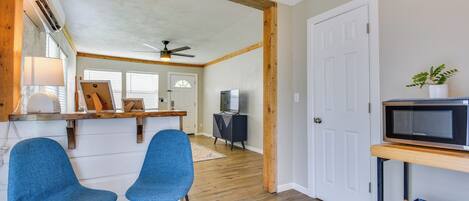 A modern kitchen with wooden beams, a ceiling fan, and a built-in microwave.