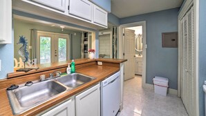 A kitchen with a wooden countertop, stainless steel sink, and white cabinets. - Walk to Padre Beach: Studio w/ Hot Tub Access (Corpus Christi)