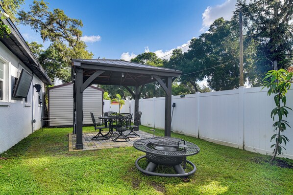 A backyard with a covered patio, a grill, and a dining set. - Hot Tub & Fenced Yard: Tranquil Home in Valrico! (Valrico)