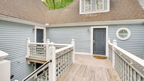 A two-story house with a wooden deck, white railings, and a grey door. - 1 Mi to Mohegan Sun: Studio w/ Pool Access (Norwich)