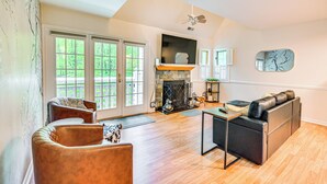 A spacious living room with a fireplace, leather seating, and large windows. - 1 Mi to Mohegan Sun: Studio w/ Pool Access (Norwich)