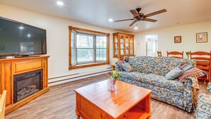 A living room with a fireplace, a television, a sofa, and a ceiling fan. - Pet-friendly Little Egg Harbor Home w/ Fenced Yard (Tuckerton)