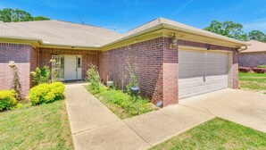 A single-story brick house with a front garage, a small front porch, and a well-maintained lawn. - 11 Mi to Dtwn Little Rock: Home w/ Large Deck! (Mabelvale)