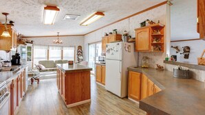 Une cuisine spacieuse avec des meubles en bois, un îlot central et un réfrigérateur.