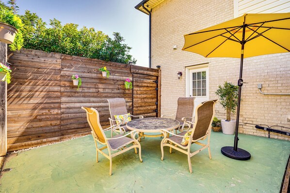 A patio with a wooden fence, a round table, and four chairs. - Explore & Unwind: Charming Bedford Apartment (Bedford)