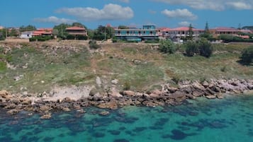 A coastal property with a rocky shoreline and clear blue waters.
