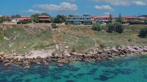 A coastal property with a rocky shoreline and clear blue waters. - Hotel Baia Mare Blu  (Isola di Capo Rizzuto)